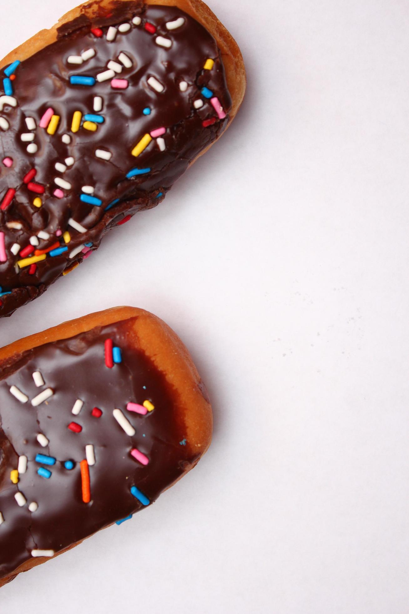 Chocolate donut bar topped with multicolored sugar flakes. laid on a white background 13310510