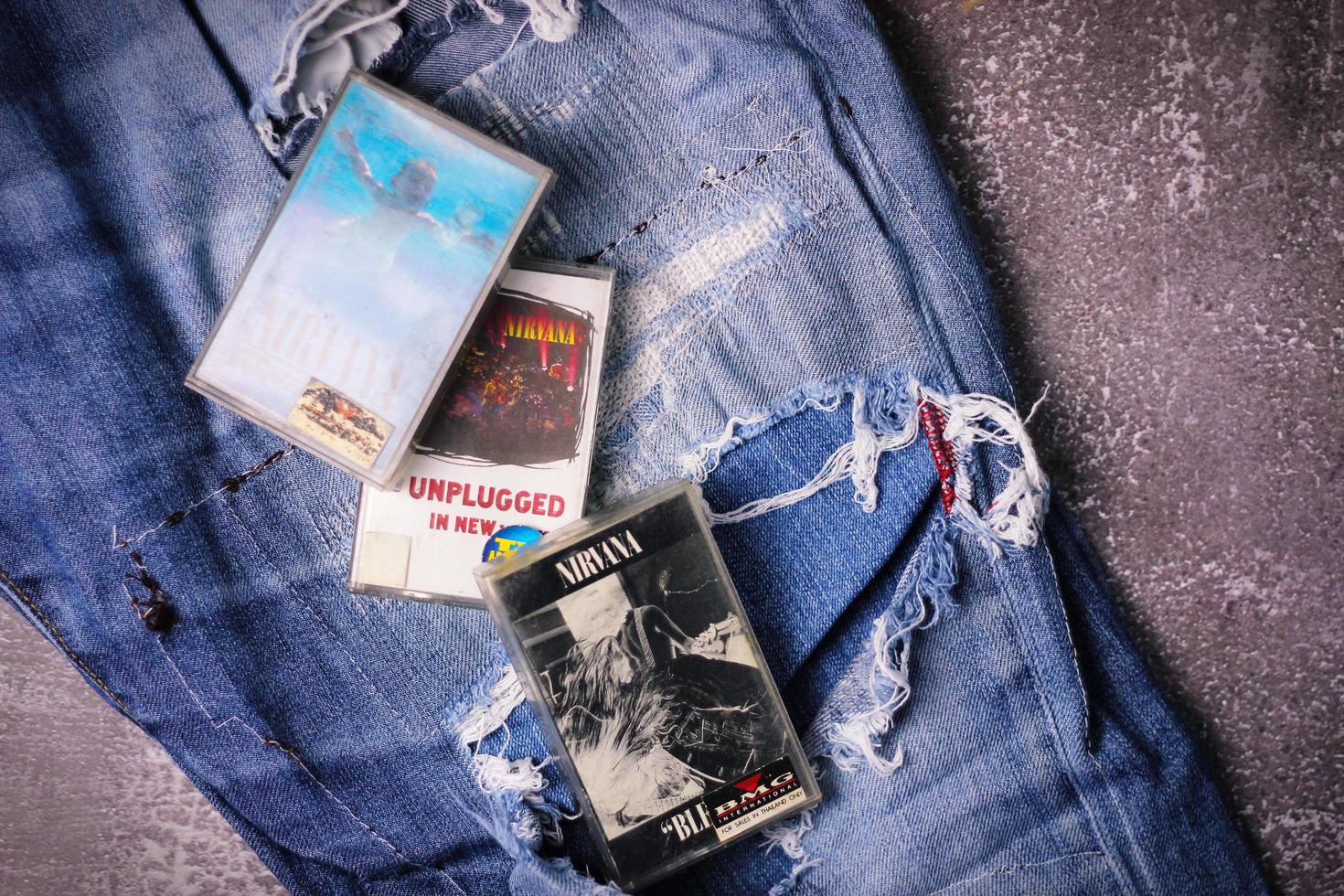 WASHINGTON USA - September 30 2022  Nirvana's cassette tape and Ripped jeans or Torn jeans. A symbol of the grunge or Seattle sound. photo