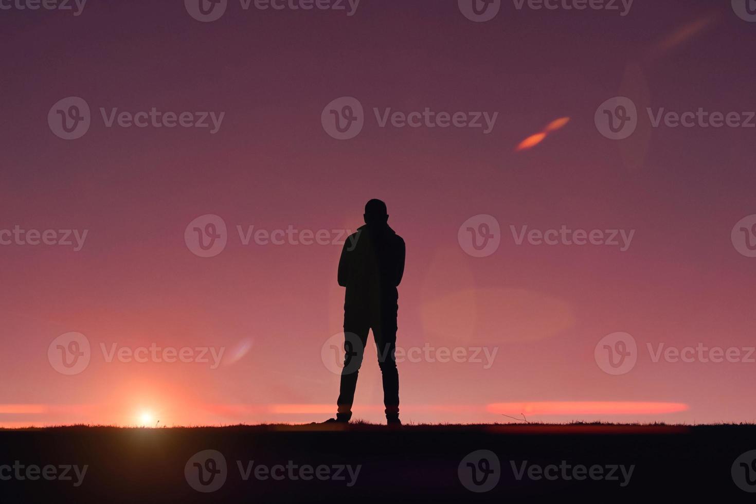man trekking in the mountain with a sunset background in summertime photo