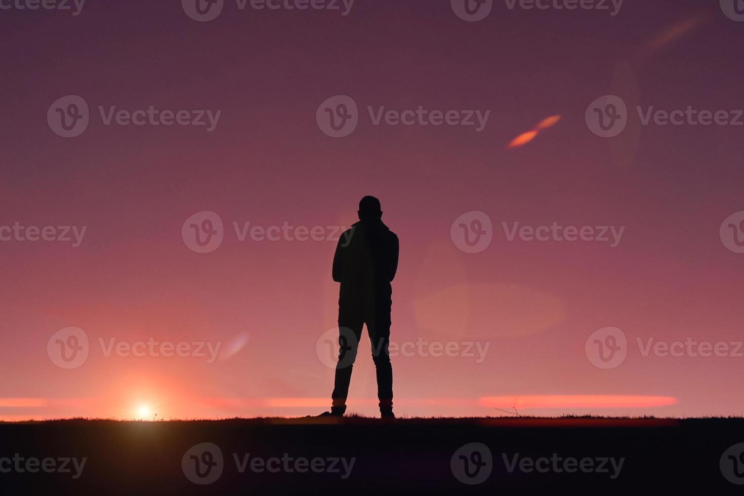 man trekking in the mountain with a sunset background in summertime photo