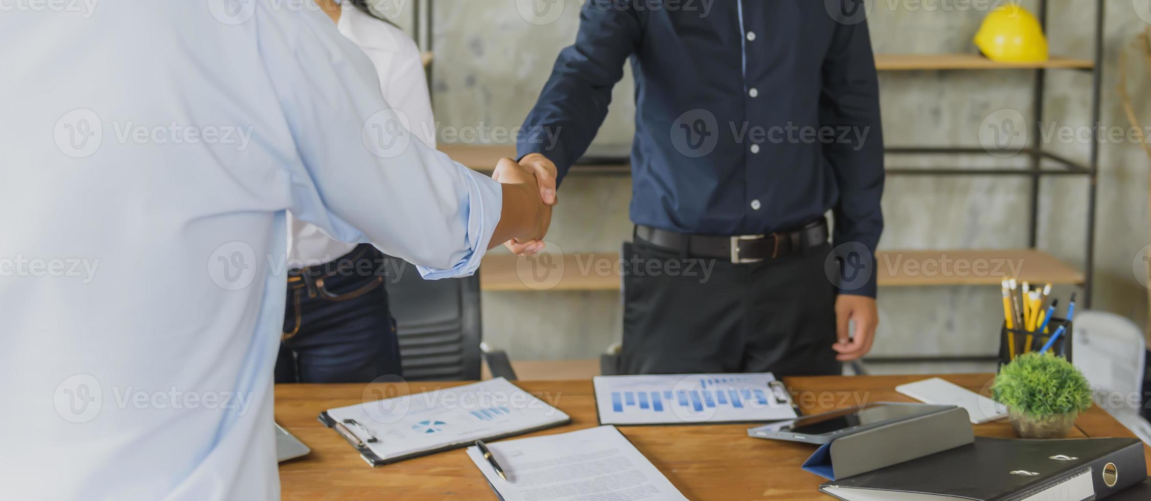 dos hombres de negocios confiados se dieron la mano durante las reuniones de oficina. foto