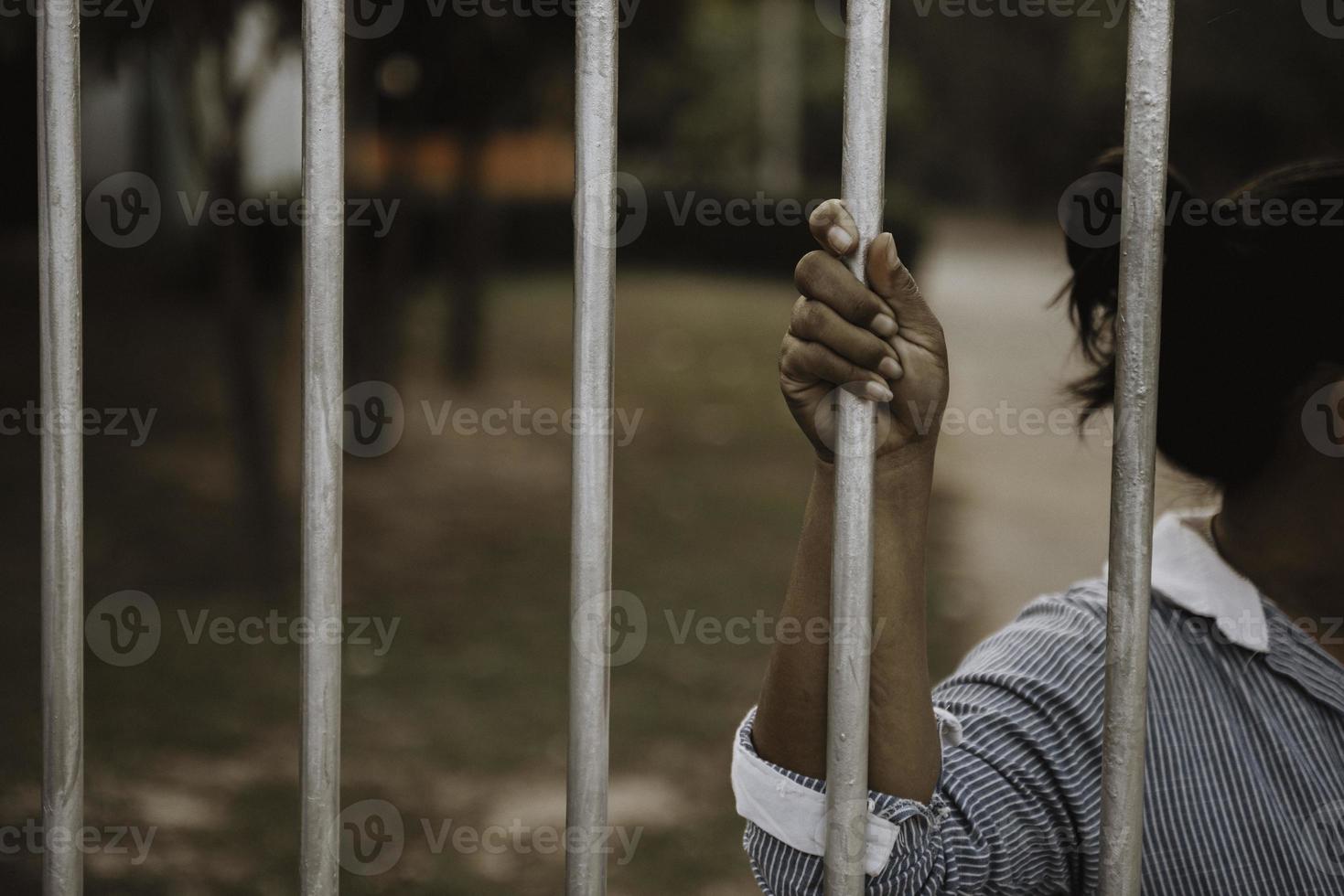 Hand of the prisoner on a steel lattice close up photo