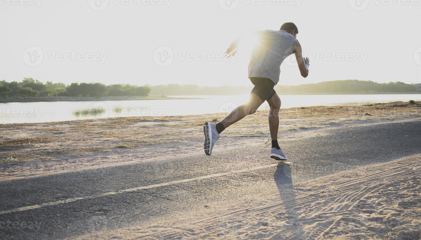 The silhouette of a man running is exercising the evening. photo