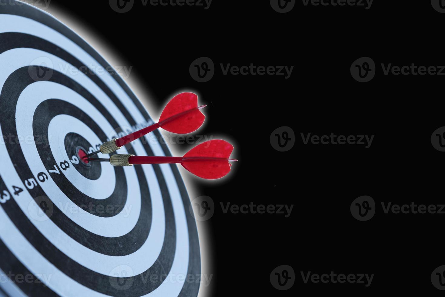 Two dart hit it's target on a red background, concept for success, photo