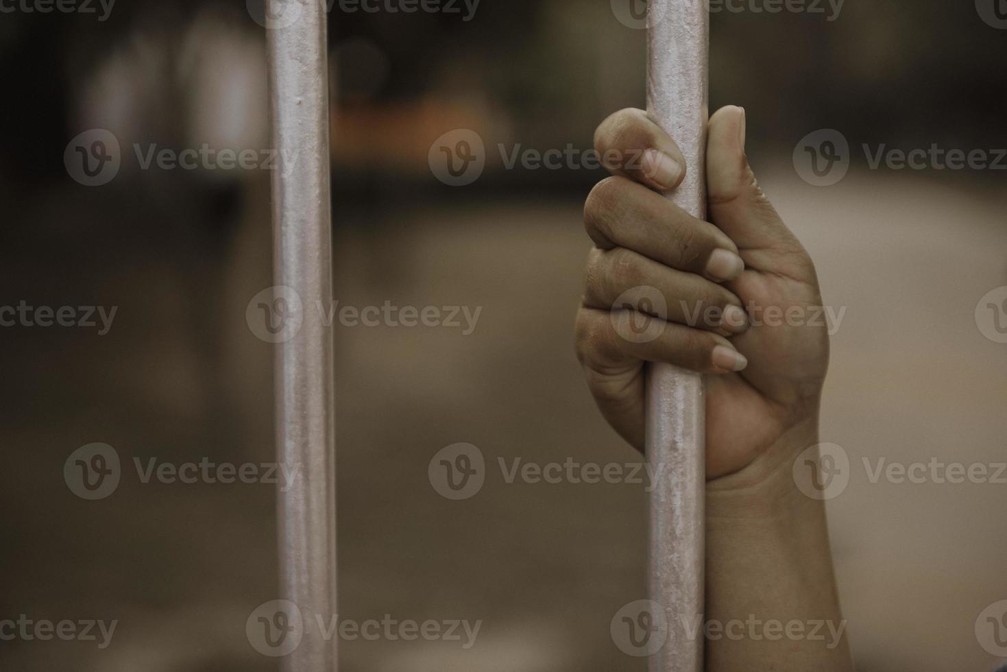 Hand of the prisoner on a steel lattice close up photo