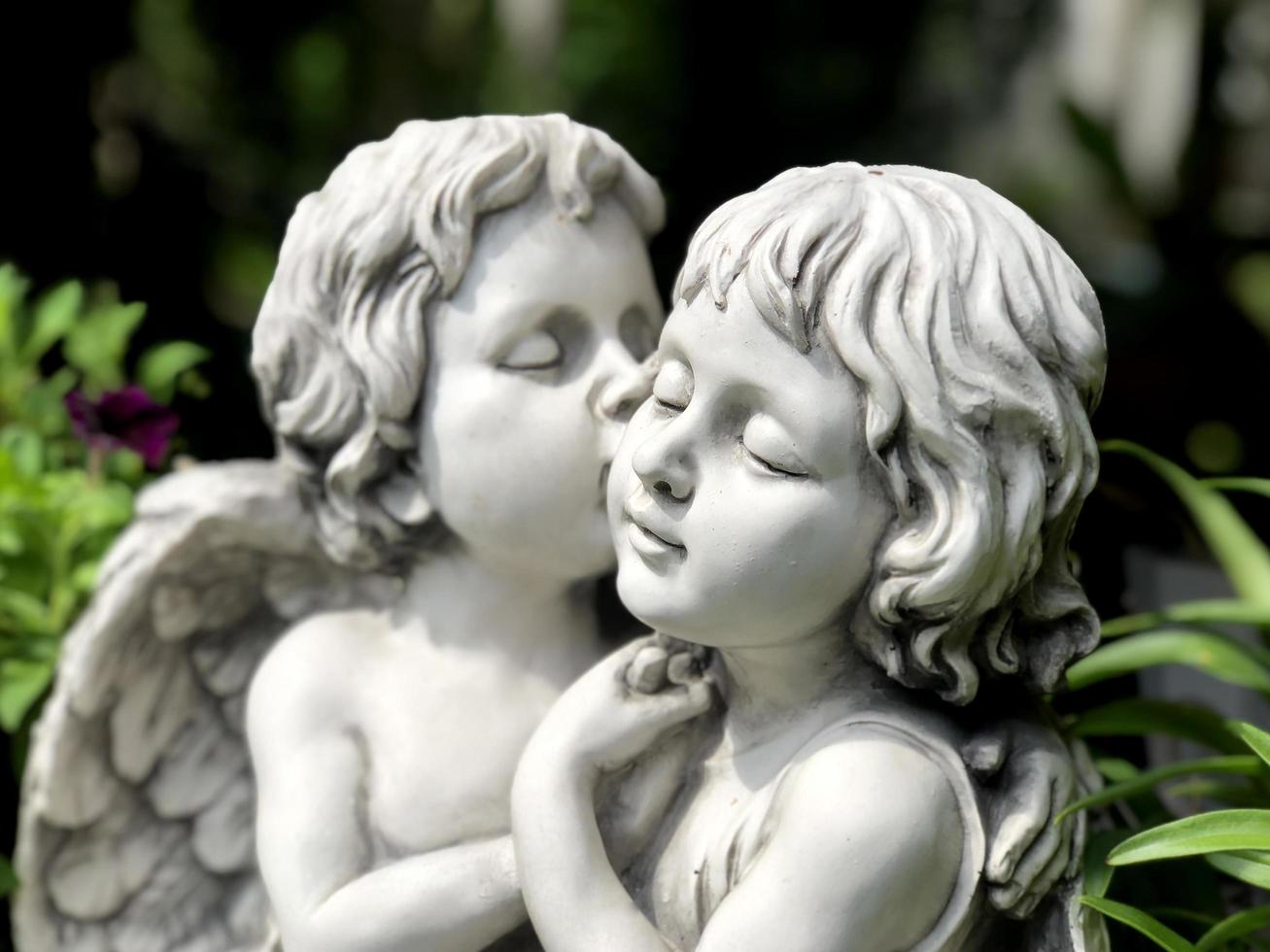 Couple cupids sculpture kissing close up. Valentine background photo