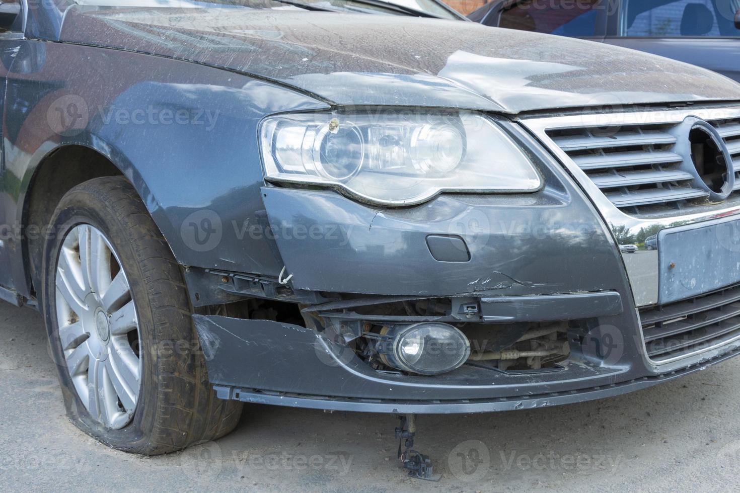 Car with a broken bumper and a flat tire, car repair after a collision, repair after an accident photo