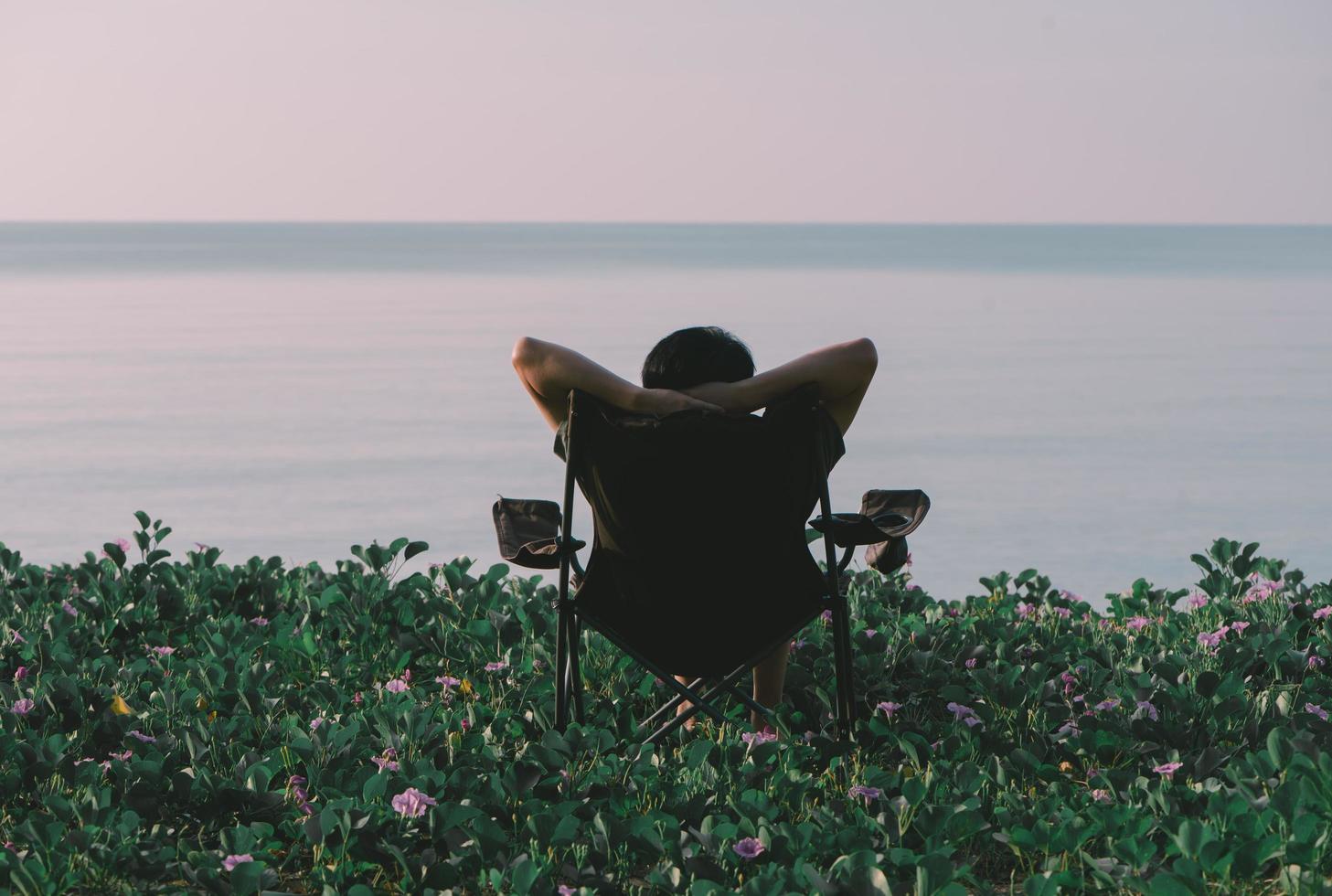 hombre relajándose en la playa, vista trasera, saludable y concepto de vacaciones. foto