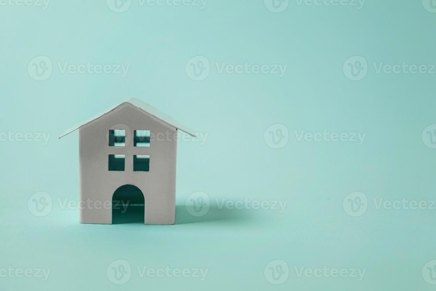 Simply design with miniature white toy house isolated on blue pastel colourful trendy background. Mortgage property insurance dream home concept. Copy space. photo