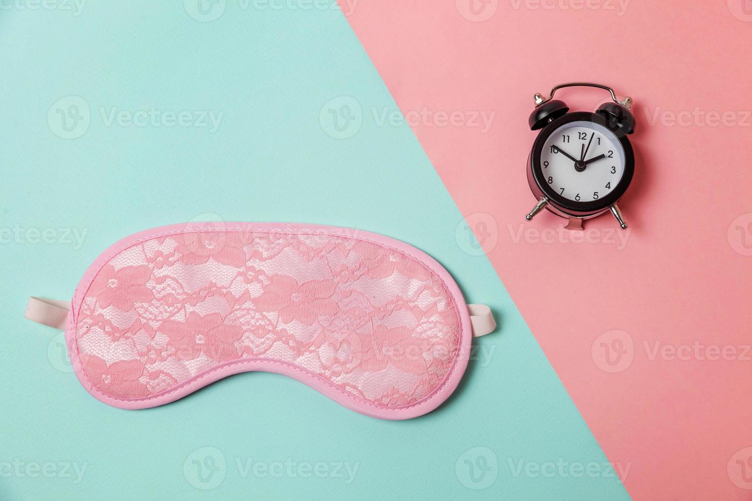 Sleeping eye mask, alarm clock isolated on blue pink pastel colorful trendy geometric background Do not disturb me, let me sleep. Rest, good night, siesta, insomnia, relaxation, tired, travel concept. photo