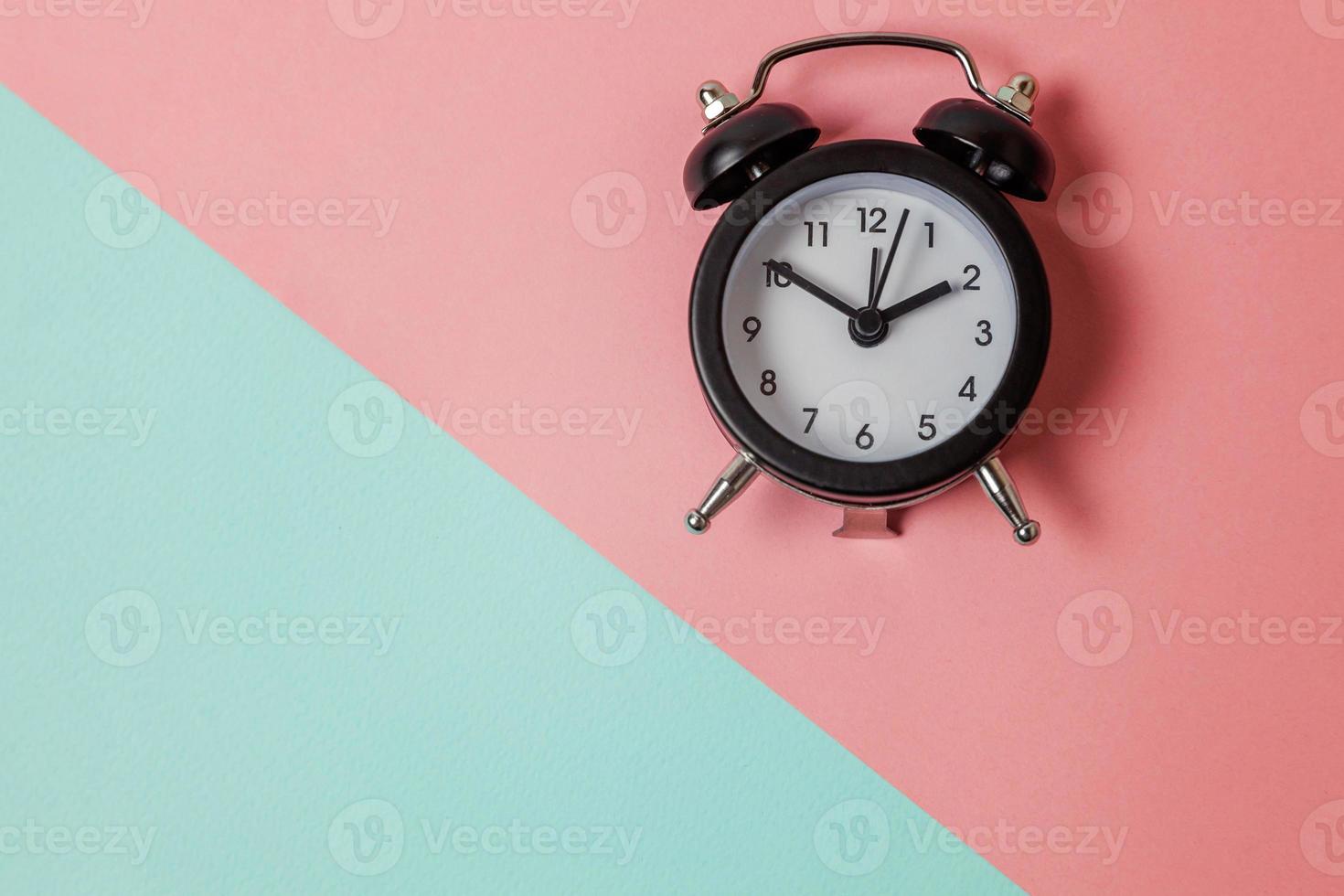 Ringing twin bell vintage classic alarm clock on blue pink pastel colorful trendy geometric background. Rest hours time of life good morning night wake up awake concept. Flat lay top view copy space. photo