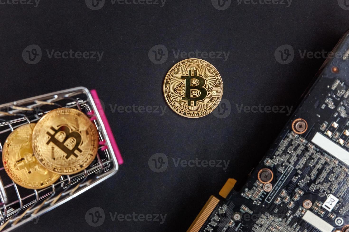 Cryptocurrency golden bitcoin coin lying in shopping cart and video card. Electronic virtual money for web banking and international network payment. Symbol of crypto virtual currency. Mining concept. photo