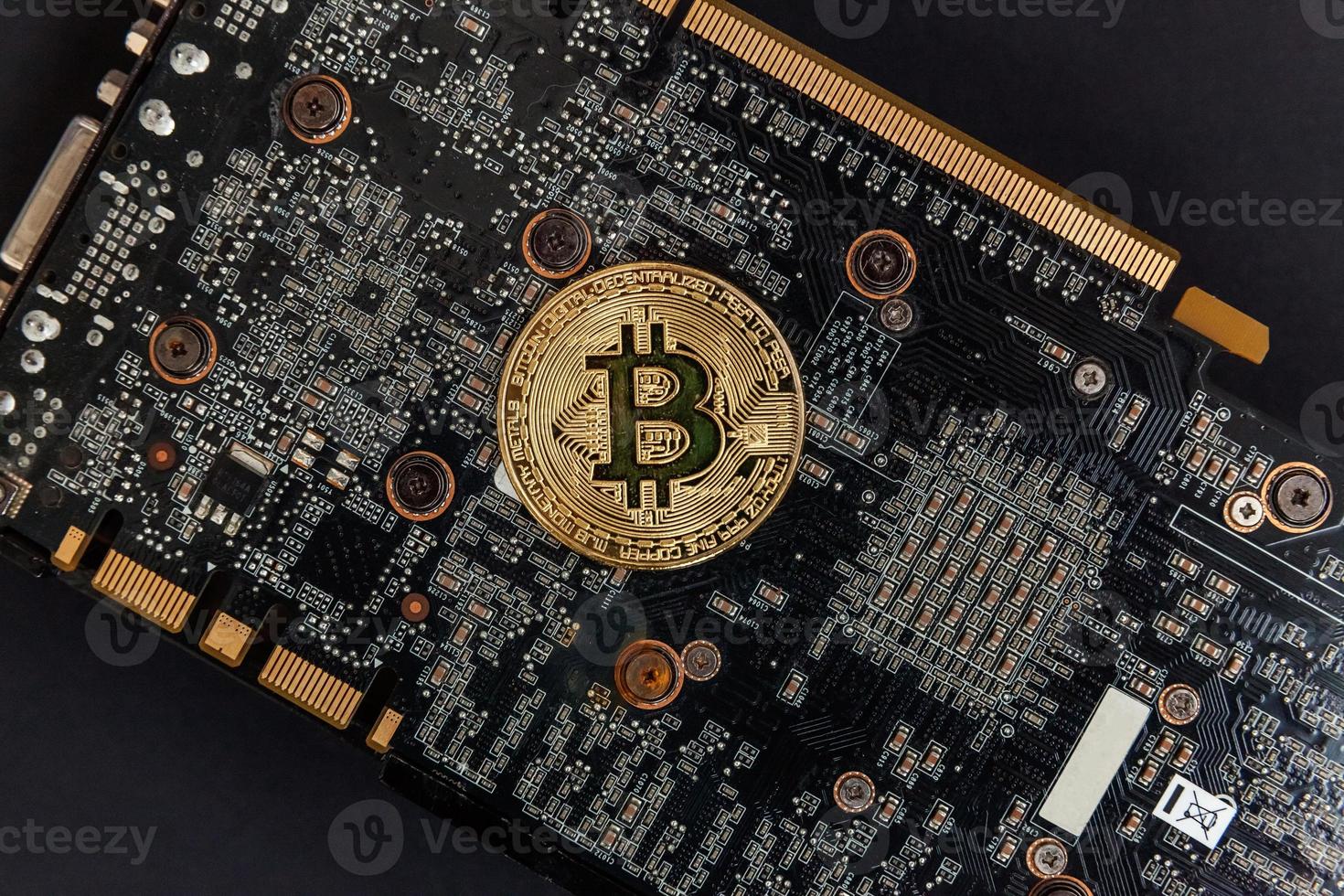 Cryptocurrency golden bitcoin coin lying on video card. Electronic virtual money for web banking and international network payment. Symbol of crypto virtual currency. Mining concept. photo
