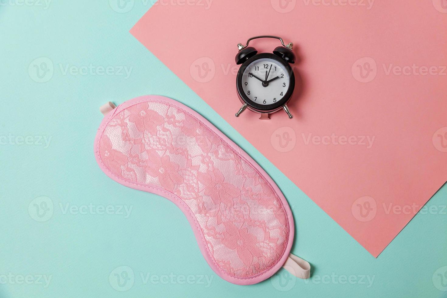 Sleeping eye mask, alarm clock isolated on blue pink pastel colorful trendy geometric background Do not disturb me, let me sleep. Rest, good night, siesta, insomnia, relaxation, tired, travel concept. photo