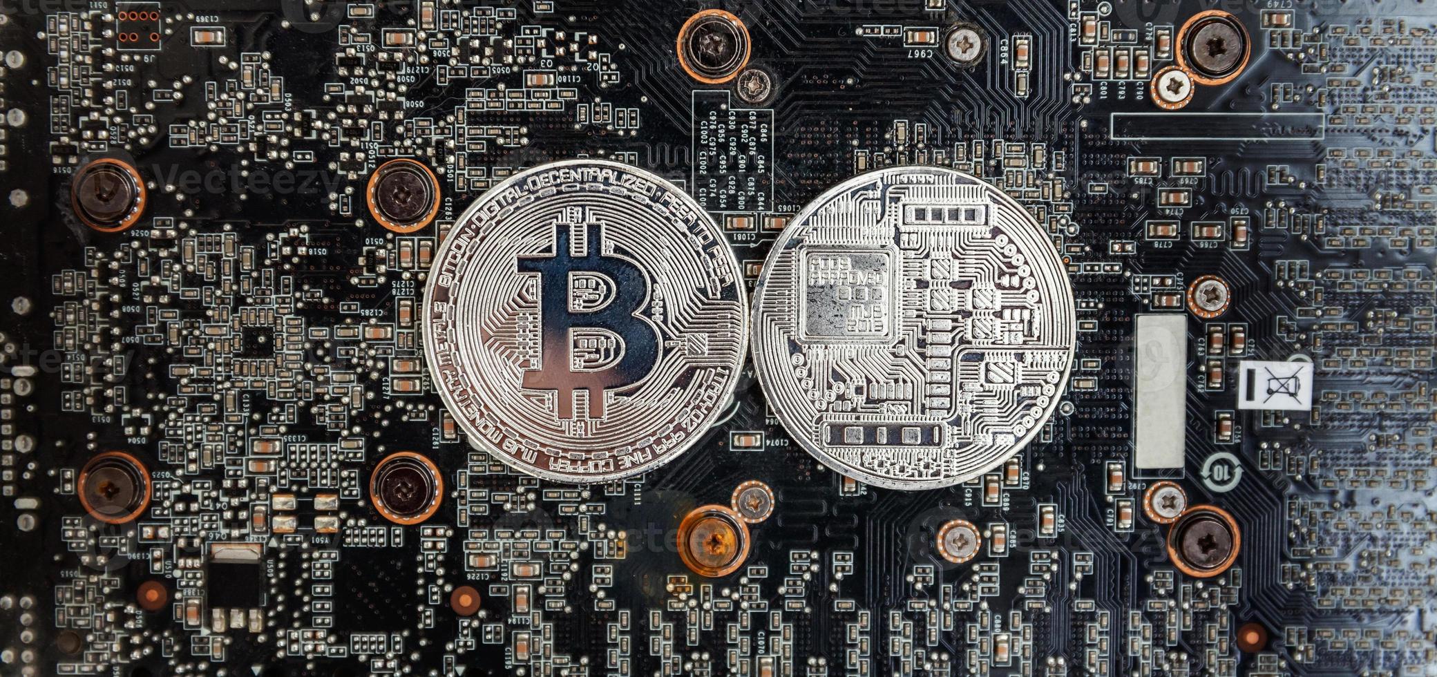 Cryptocurrency silver bitcoin coin lying on video card. Electronic virtual money for web banking and international network payment. Symbol of crypto virtual currency. Mining concept. photo