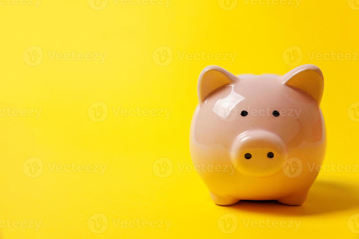 Pink piggy bank isolated on yellow colourful trendy modern fashion background. Saving investment budget wealth business retirement, financial, money, banking concept. Copy space. photo