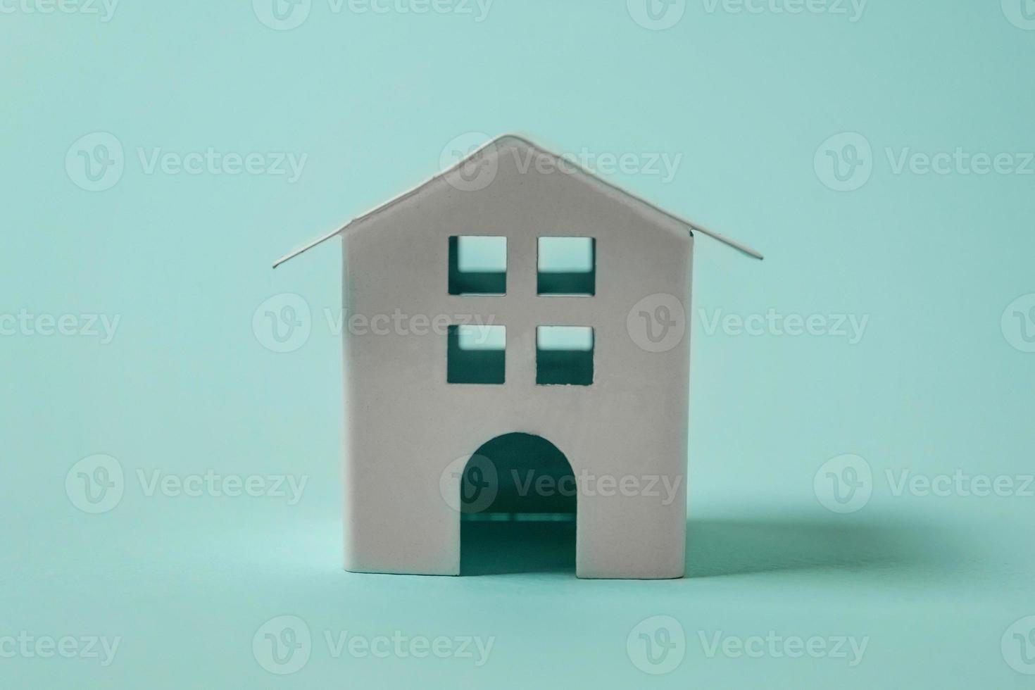 Simply design with miniature white toy house isolated on blue pastel colourful trendy background. Mortgage property insurance dream home concept. Copy space. photo