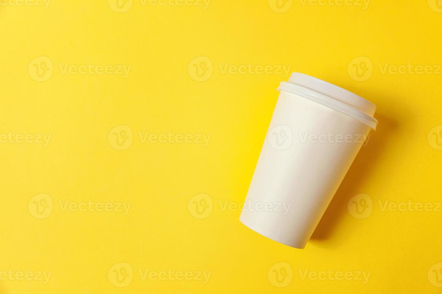 Simply flat lay design paper coffee cup on yellow colorful trendy background. Takeaway drink container. Good morning wake up awake concept. Template of drink mockup. Top view copy space. photo