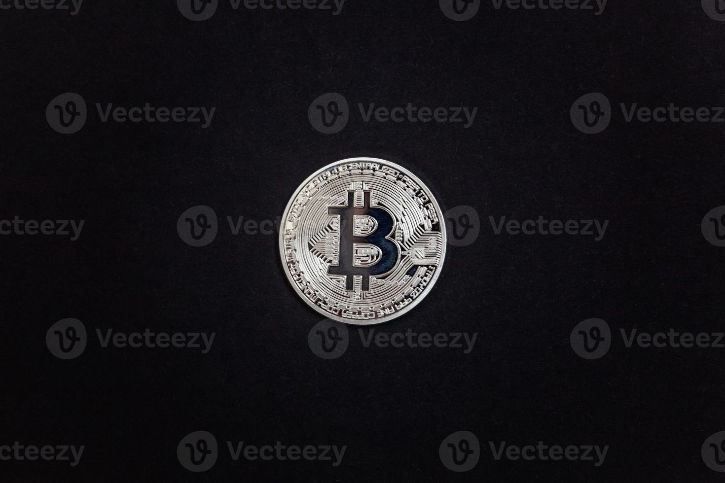 Cryptocurrency silver bitcoin coin on black background. Electronic virtual money for web banking and international network payment. Symbol of crypto virtual currency. Mining concept. photo