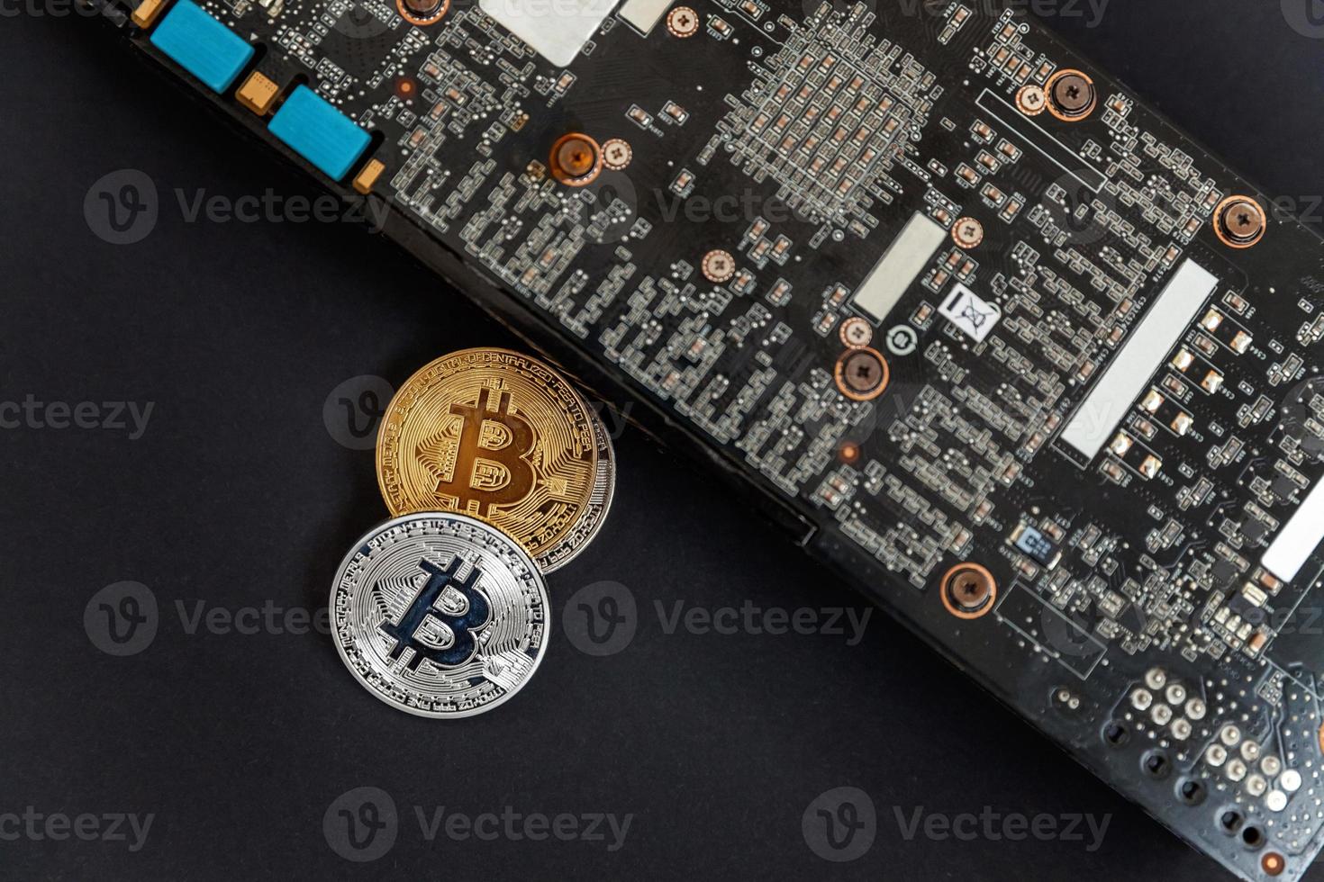 Cryptocurrency golden silver bitcoin coin lying on video card. Electronic virtual money for web banking and international network payment. Symbol of crypto virtual currency. Mining concept. photo