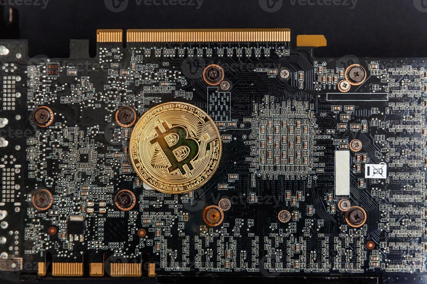 Cryptocurrency golden bitcoin coin lying on video card. Electronic virtual money for web banking and international network payment. Symbol of crypto virtual currency. Mining concept. photo