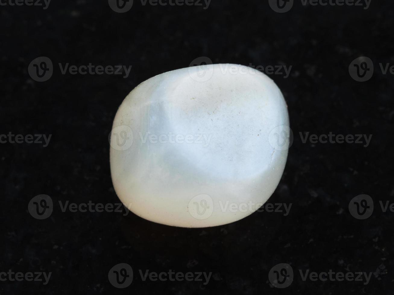polished translucent moonstone gemstone on dark photo