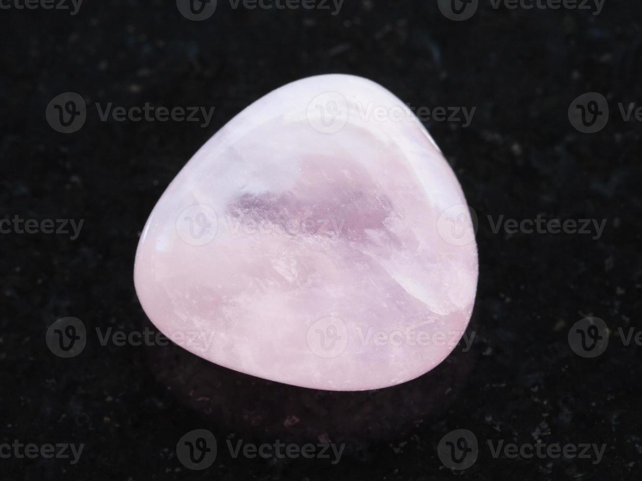 tumbled pink Quartz gem stone on dark photo