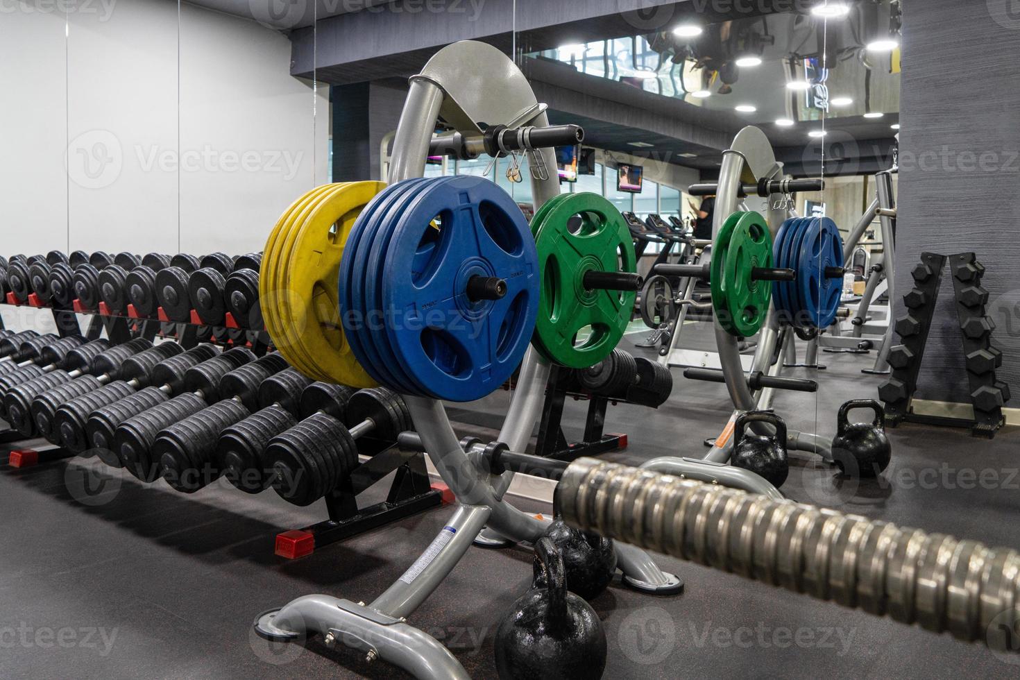 A closeup of weight plates and dumbbells in the sports complex photo