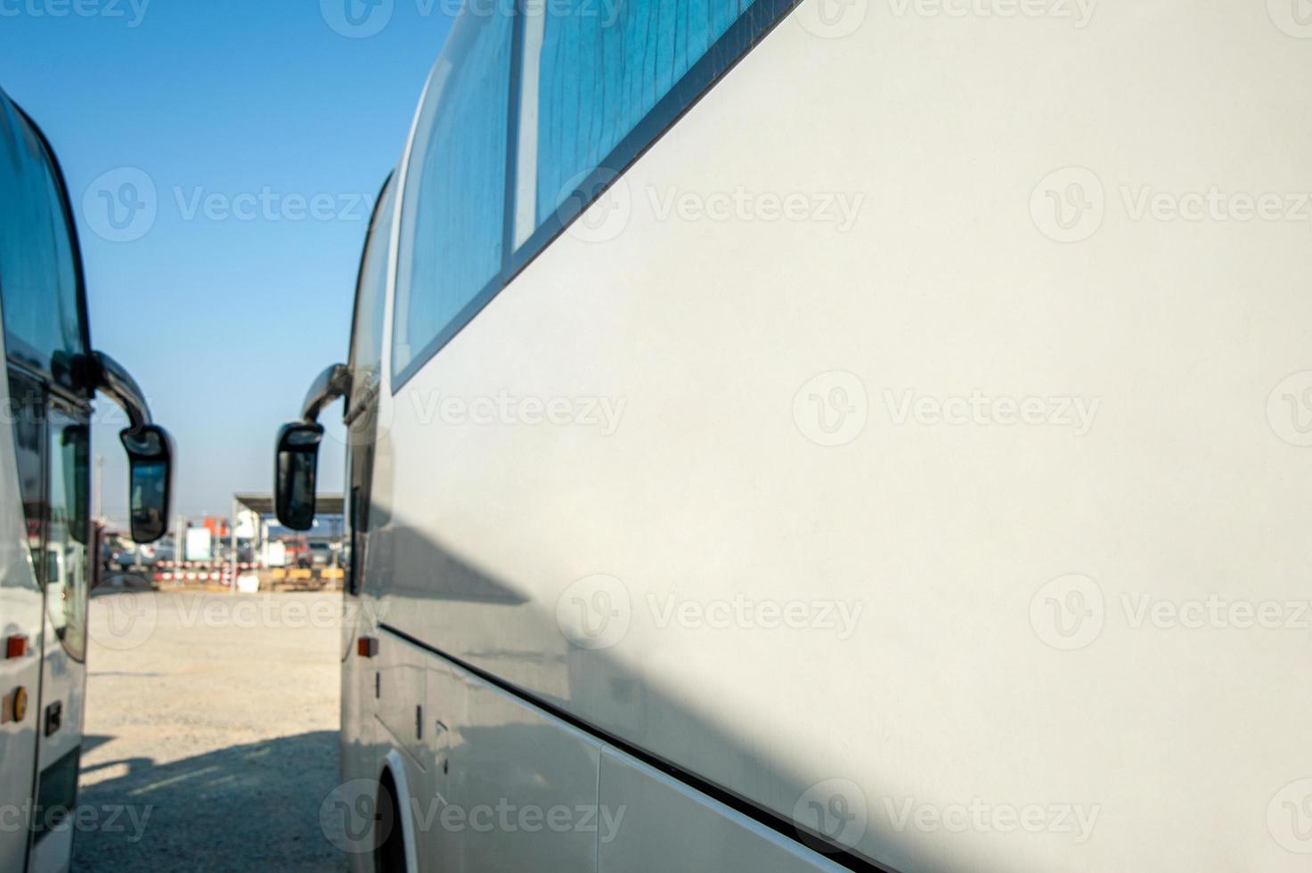 A passenger shift buses stand in a row on a construction site photo