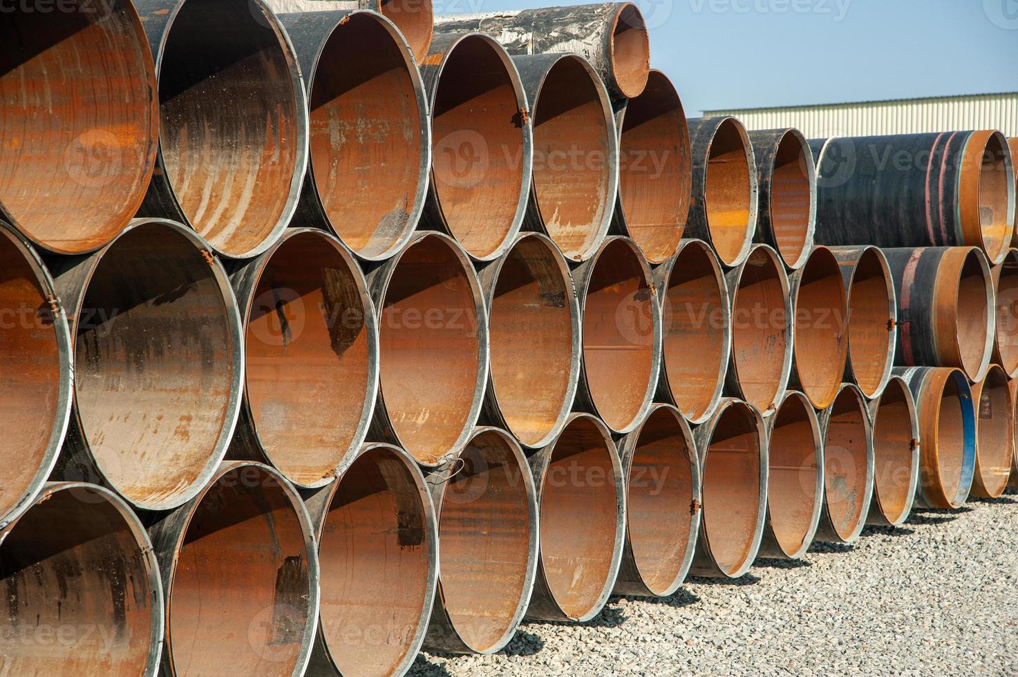 Lines of oilfield large streel pipes in an industrial construction area photo