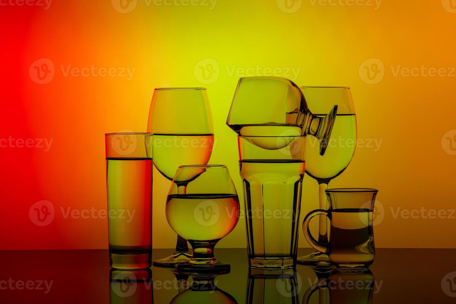 Some glasses for different drinks stacked on a colorful background photo