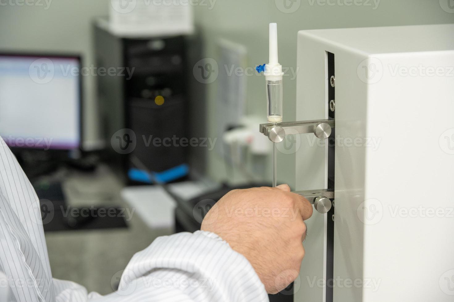 A closeup shot of hands working on a machine in a medical production warehouse for syringes photo
