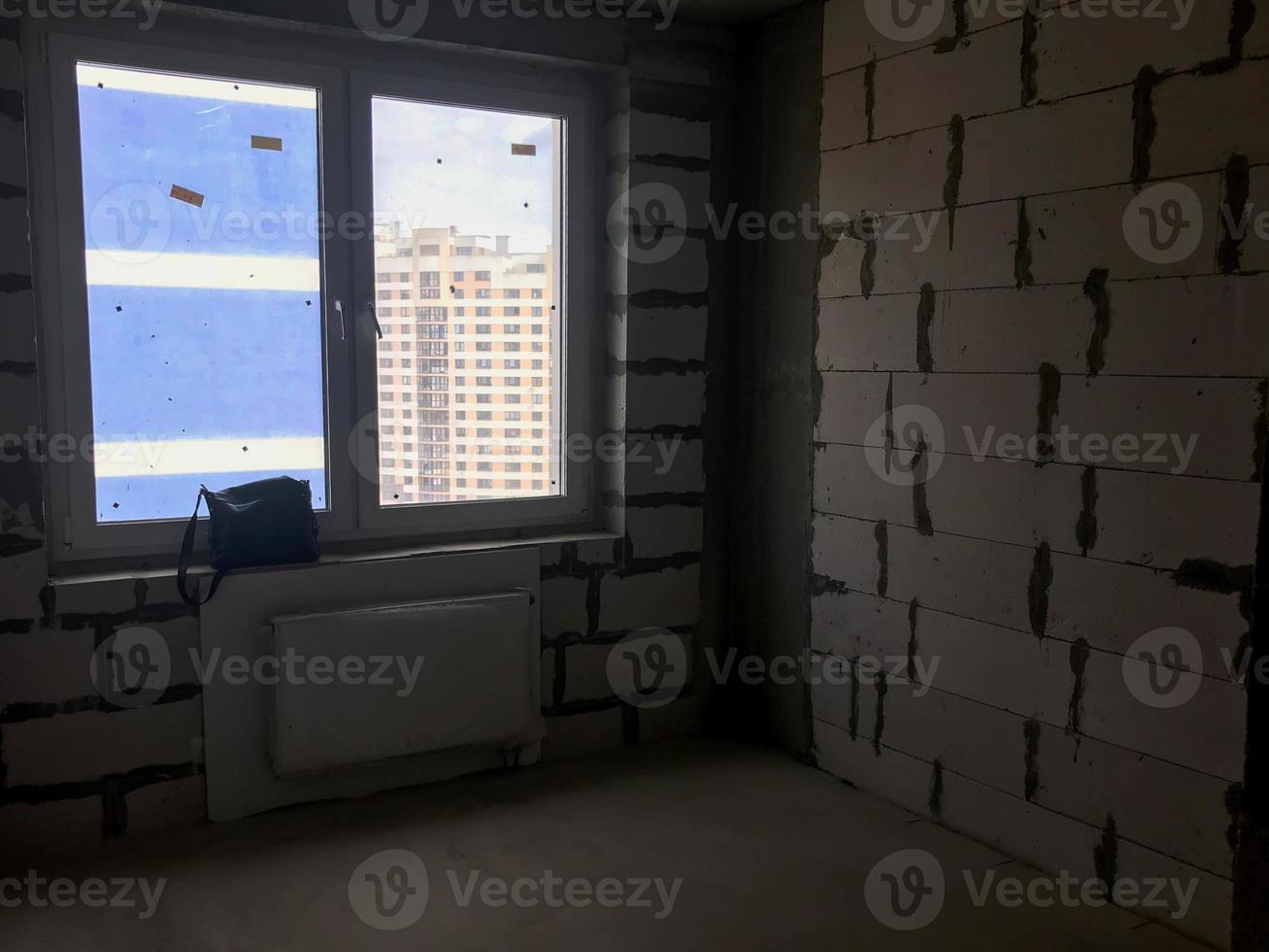 A window with a plastic profile in the new building with a free layout, in an apartment without repair, construction with a battery and walls of gas silicate blocks photo