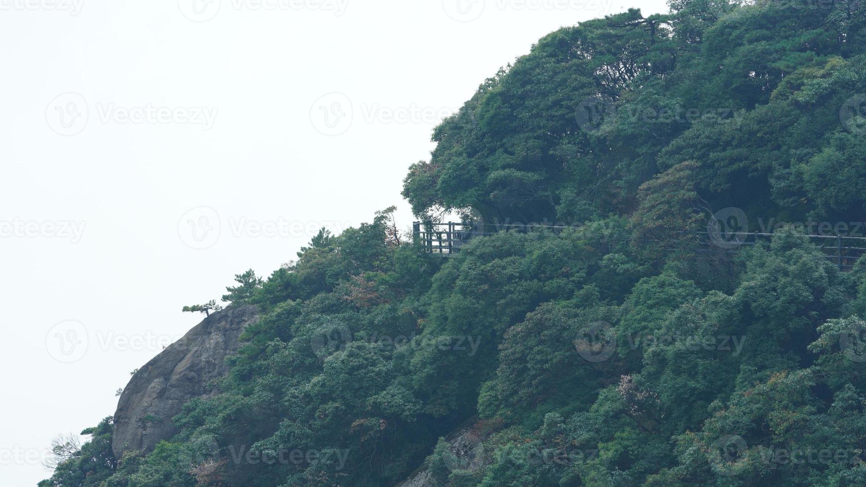 The beautiful mountains landscapes with the green forest and a plank road built along the face of a cliff in the countryside of the China photo