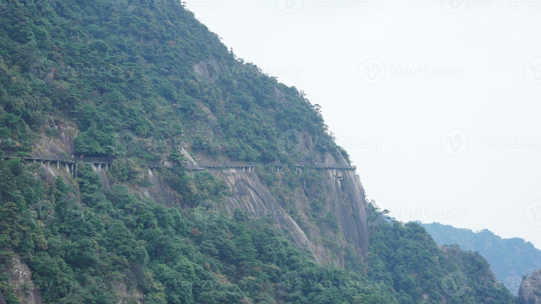The beautiful mountains landscapes with the green forest and a plank road built along the face of a cliff in the countryside of the China photo