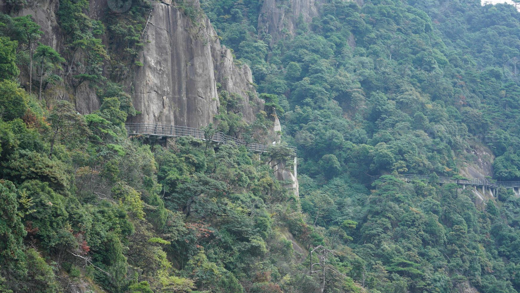 The beautiful mountains landscapes with the green forest and a plank road built along the face of a cliff in the countryside of the China photo