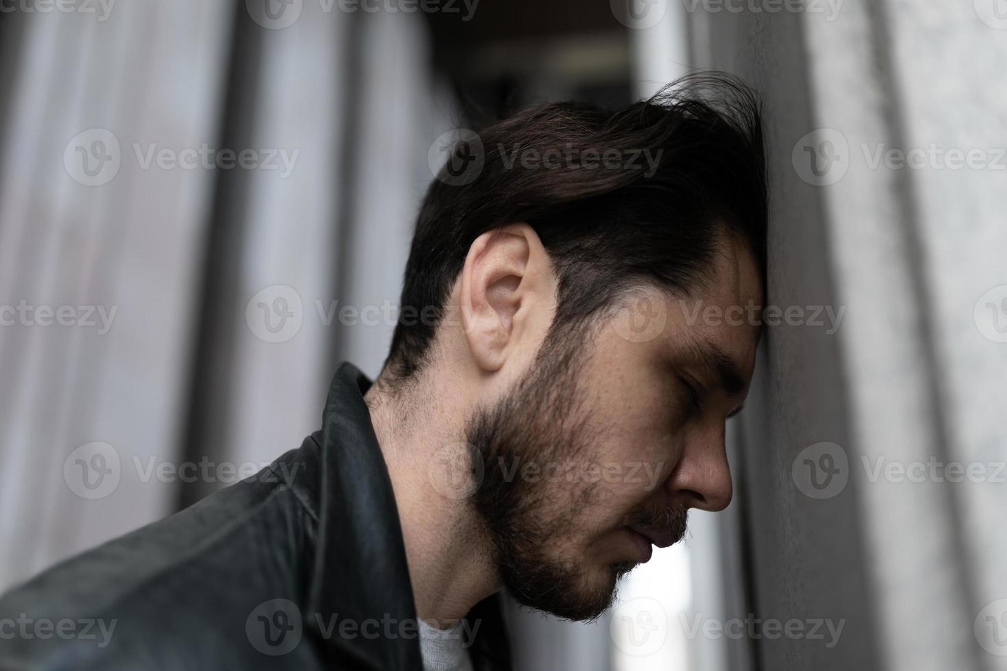 close-up portrait of a sad man suffering from depression and migraine photo