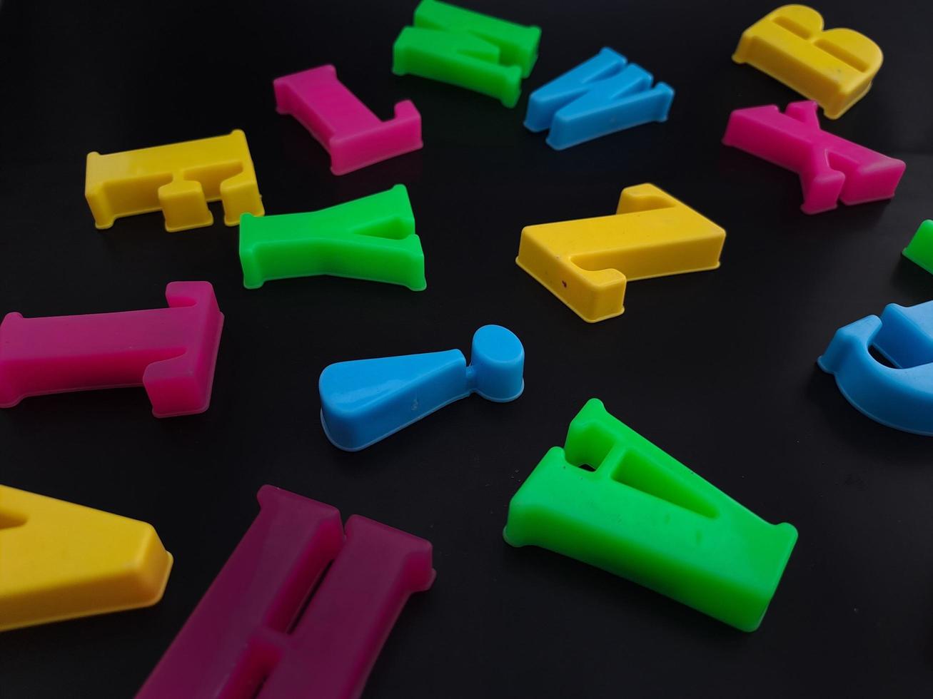 Close up of colorful alphabets on black background perfect for children's education photo