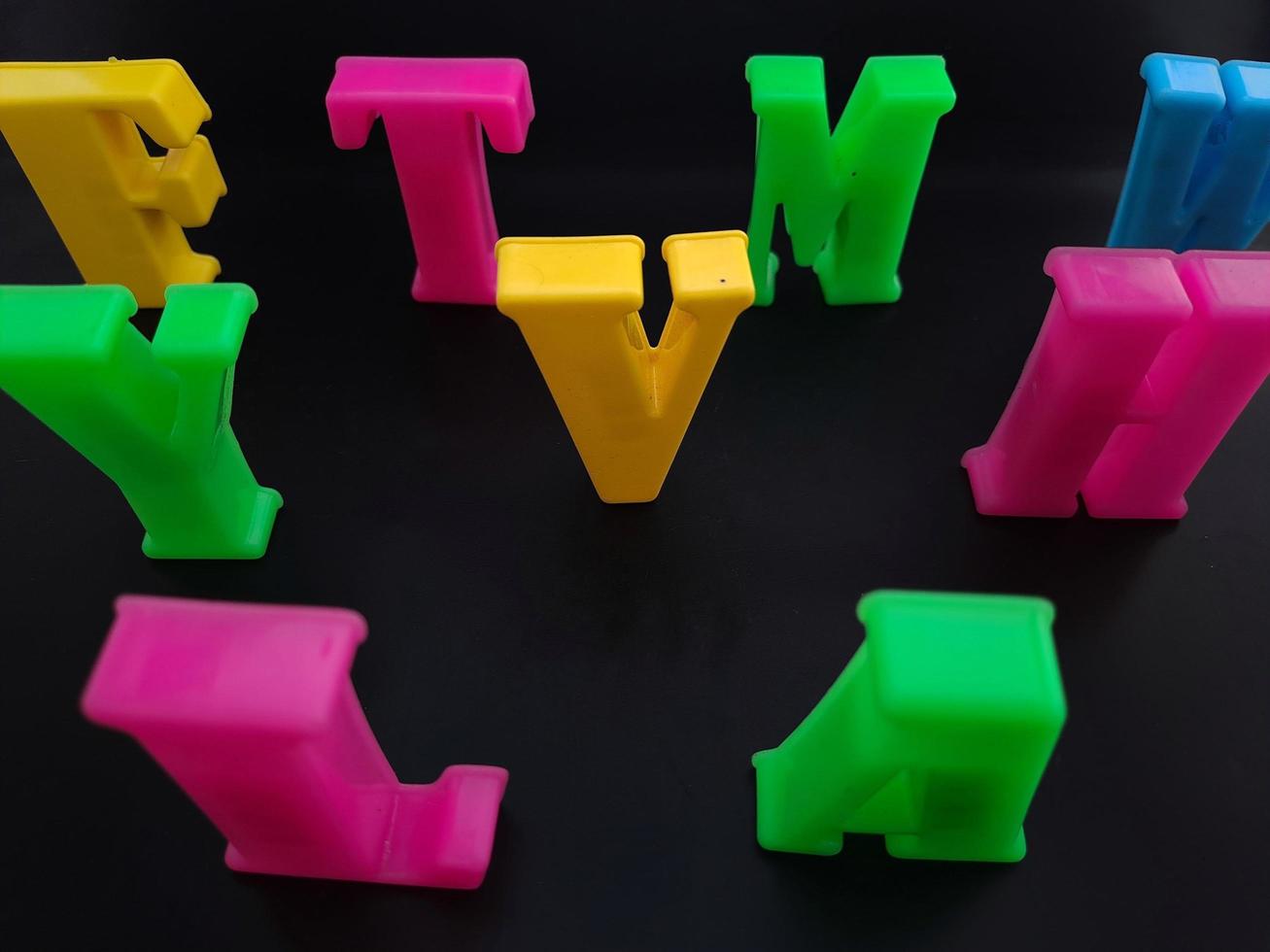 Close up of colorful alphabets on black background perfect for children's education photo