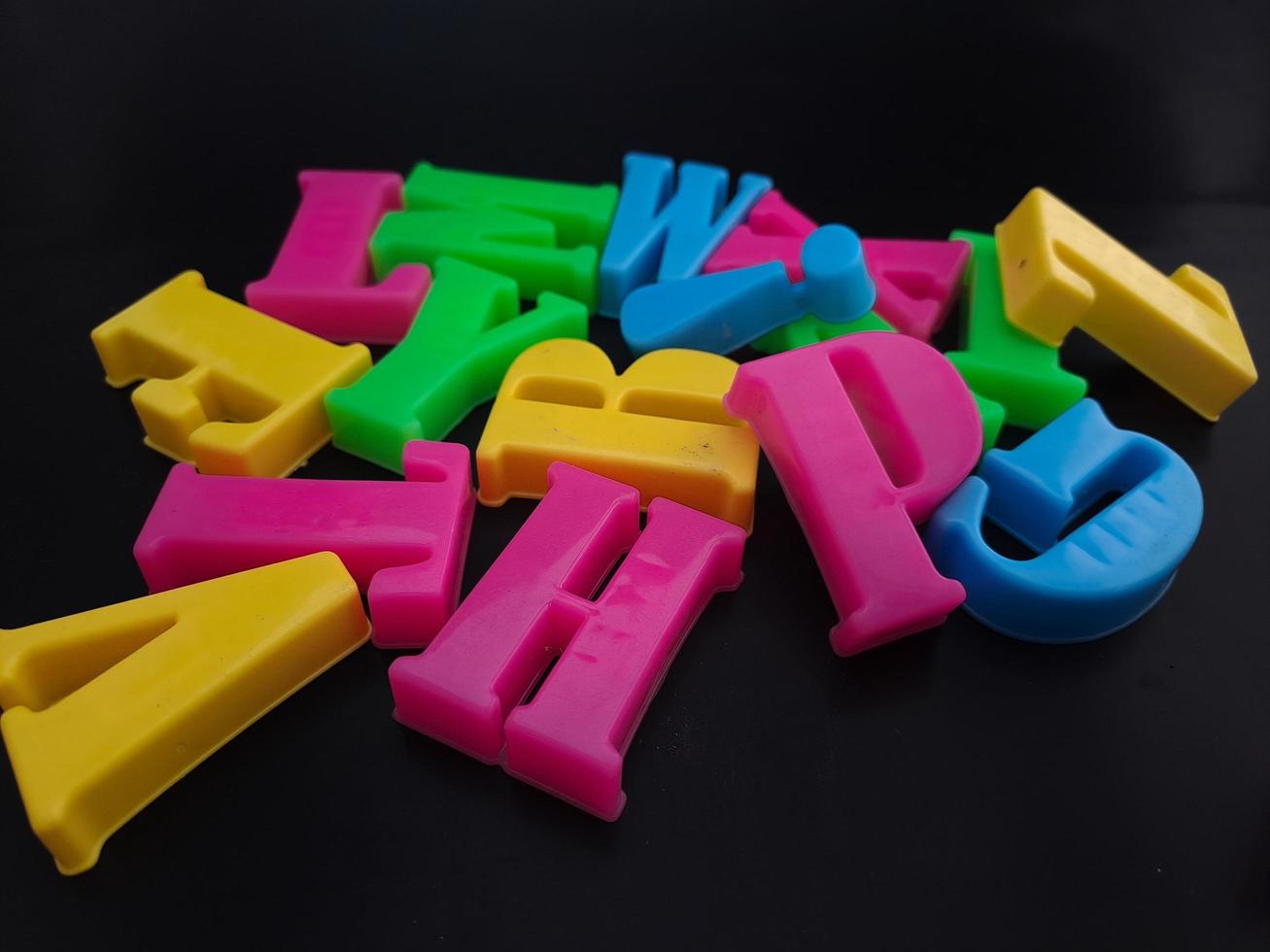 Close up of colorful alphabets on black background perfect for children's education photo