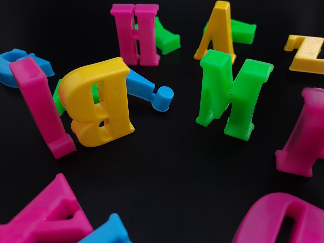 Close up of colorful alphabets on black background perfect for children's education photo