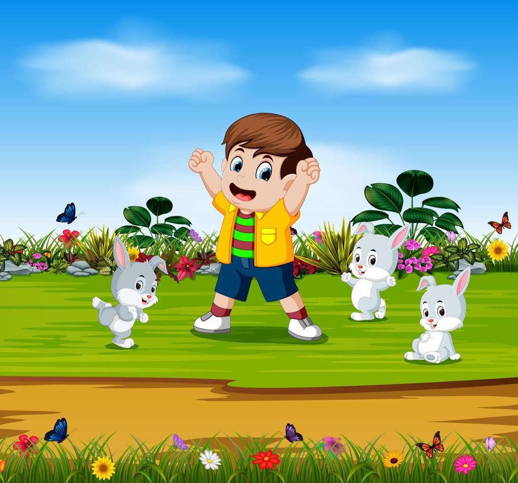 el niño está jugando con tres conejos en el jardín vector