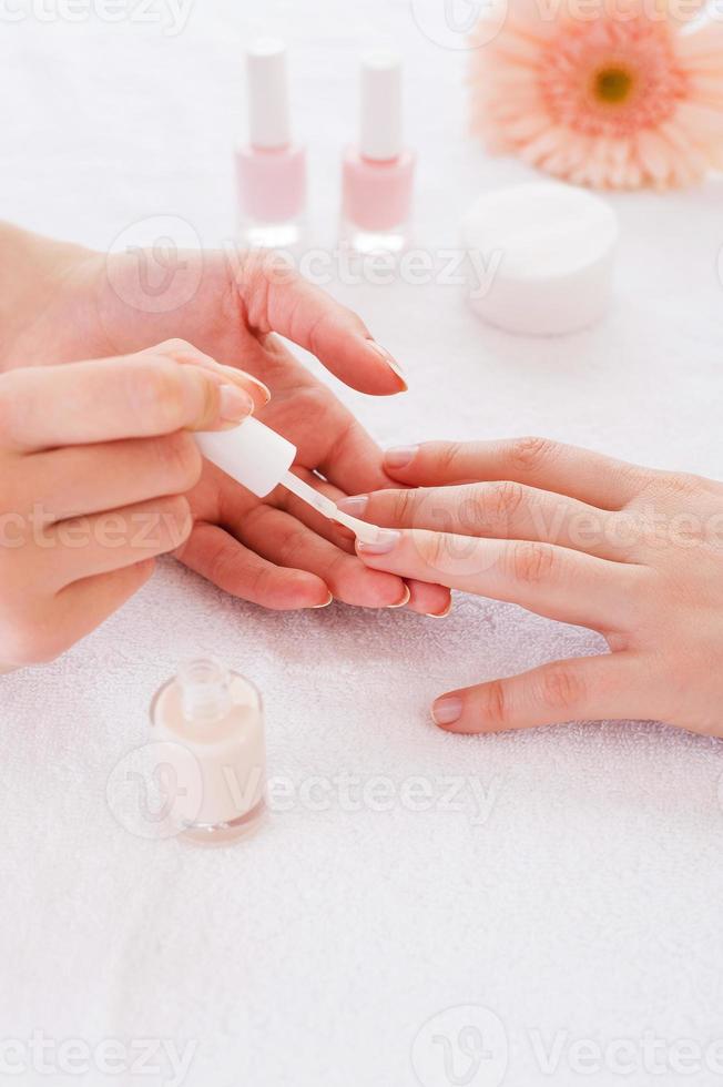 haciendo manicura. primer plano de esteticista haciendo manicura a clienta foto