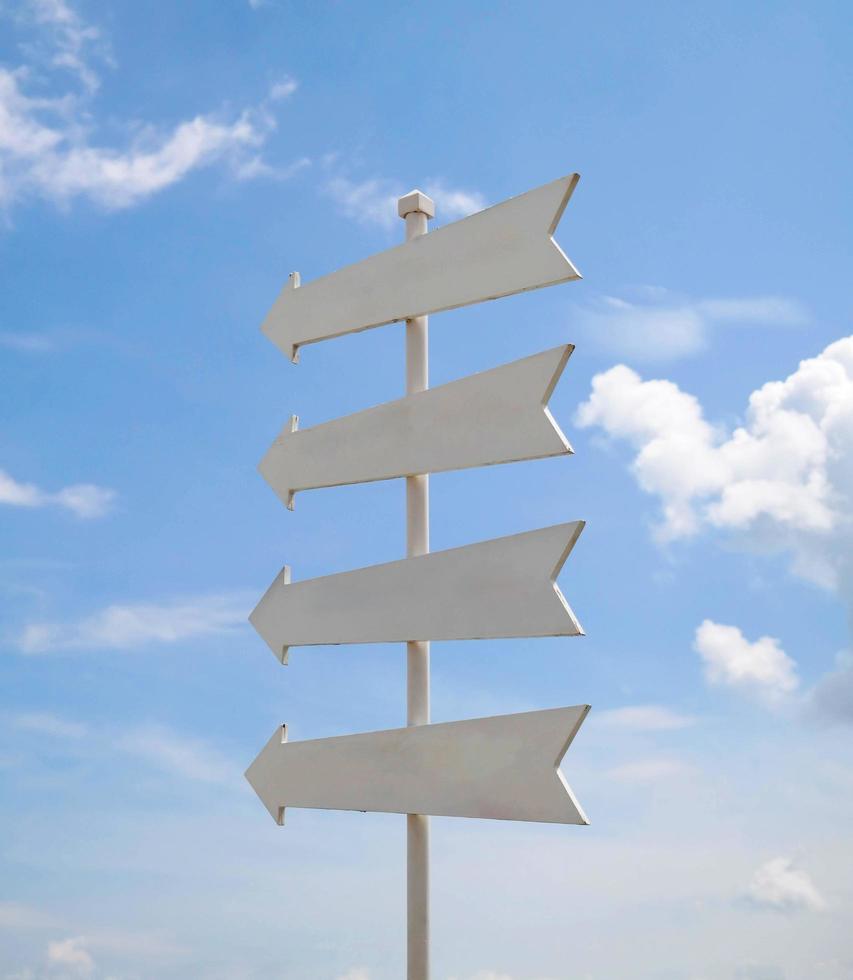 white arrow sign over blue sky photo