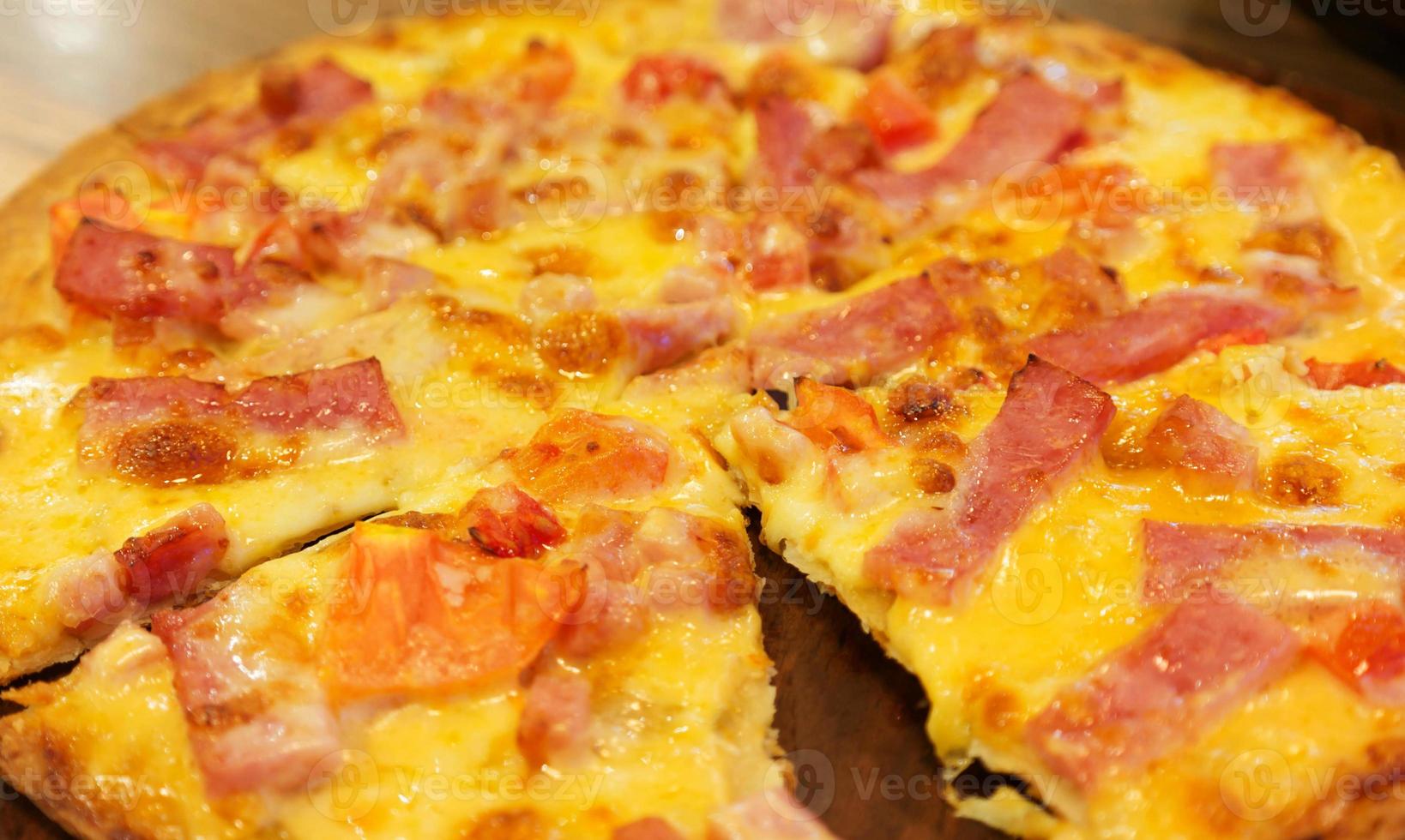 cheesy ham pizza on wooden board photo