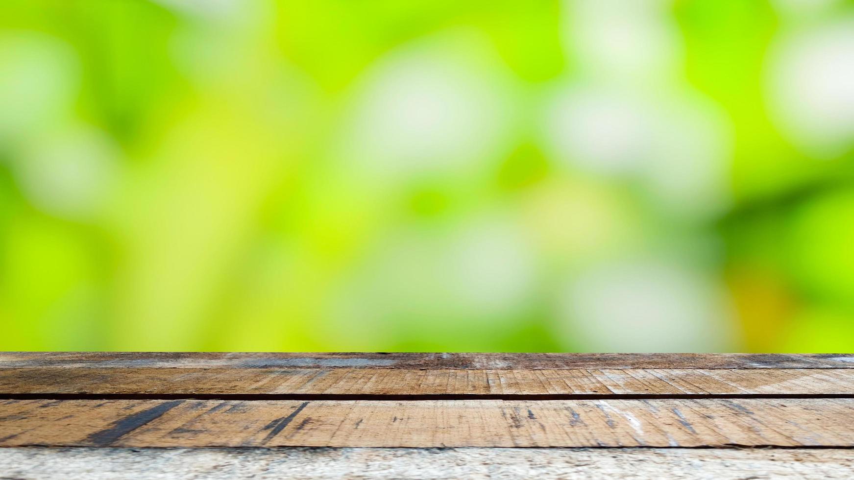 brown wooden table  green blur background  bright daylight  Use it as a product ad template. photo