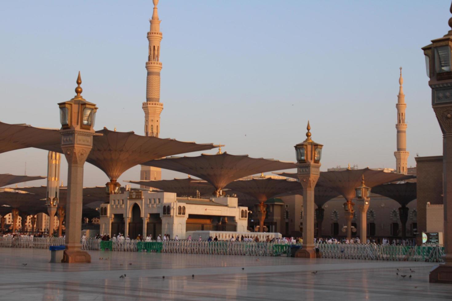 Medina, Saudi Arabia, Oct 2022 - A beautiful daytime view of Masjid Al Nabawi minarets and electronic umbrellas or canopies. photo