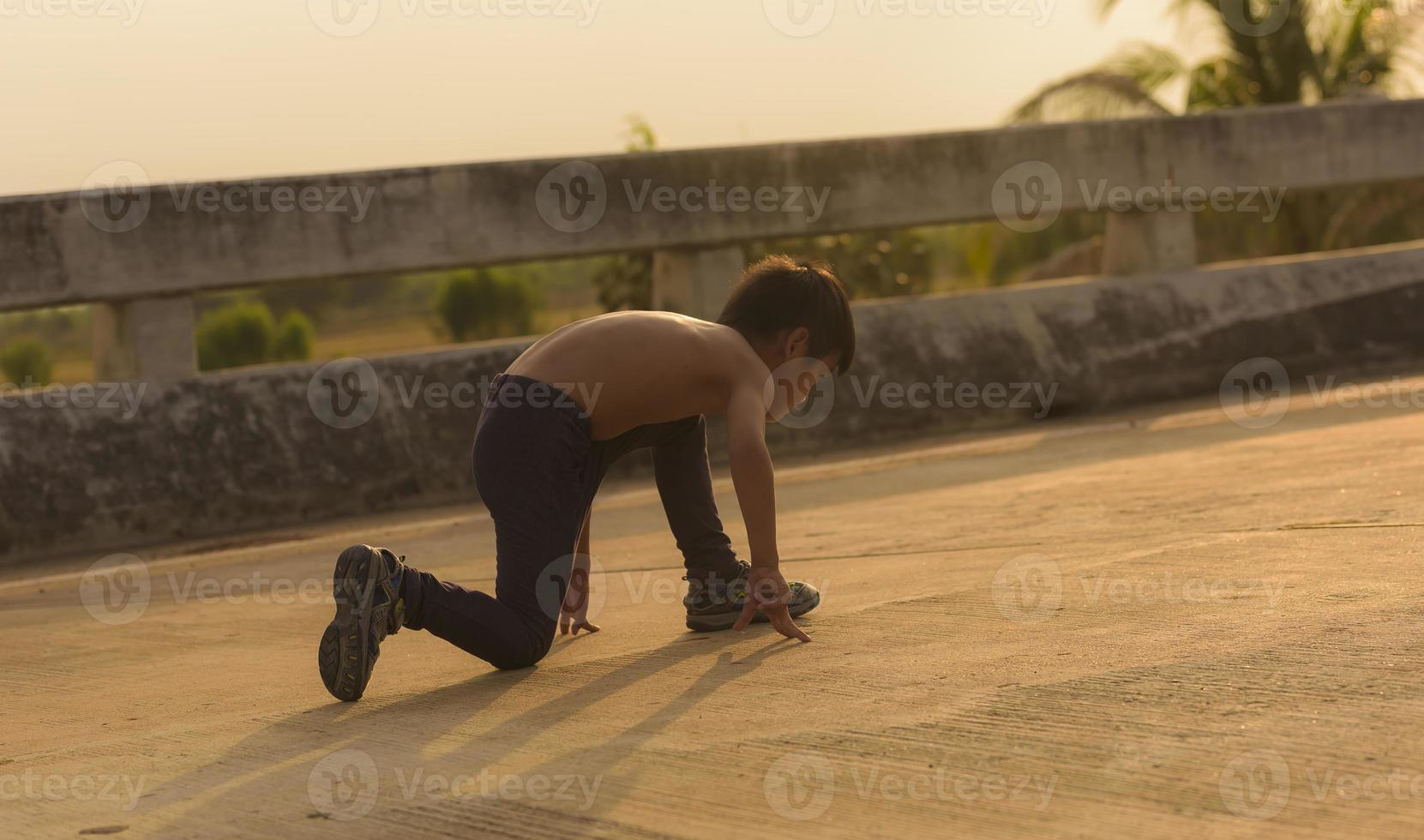 A strong little boy ran along the bridge. photo