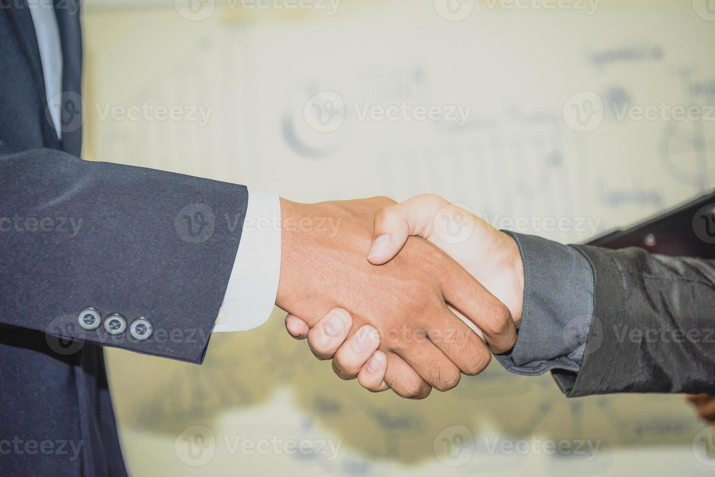 dos hombres de negocios confiados se dieron la mano durante las reuniones de oficina. foto