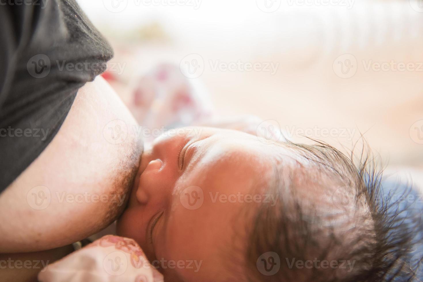 Newborn baby sucking mother's milk. photo